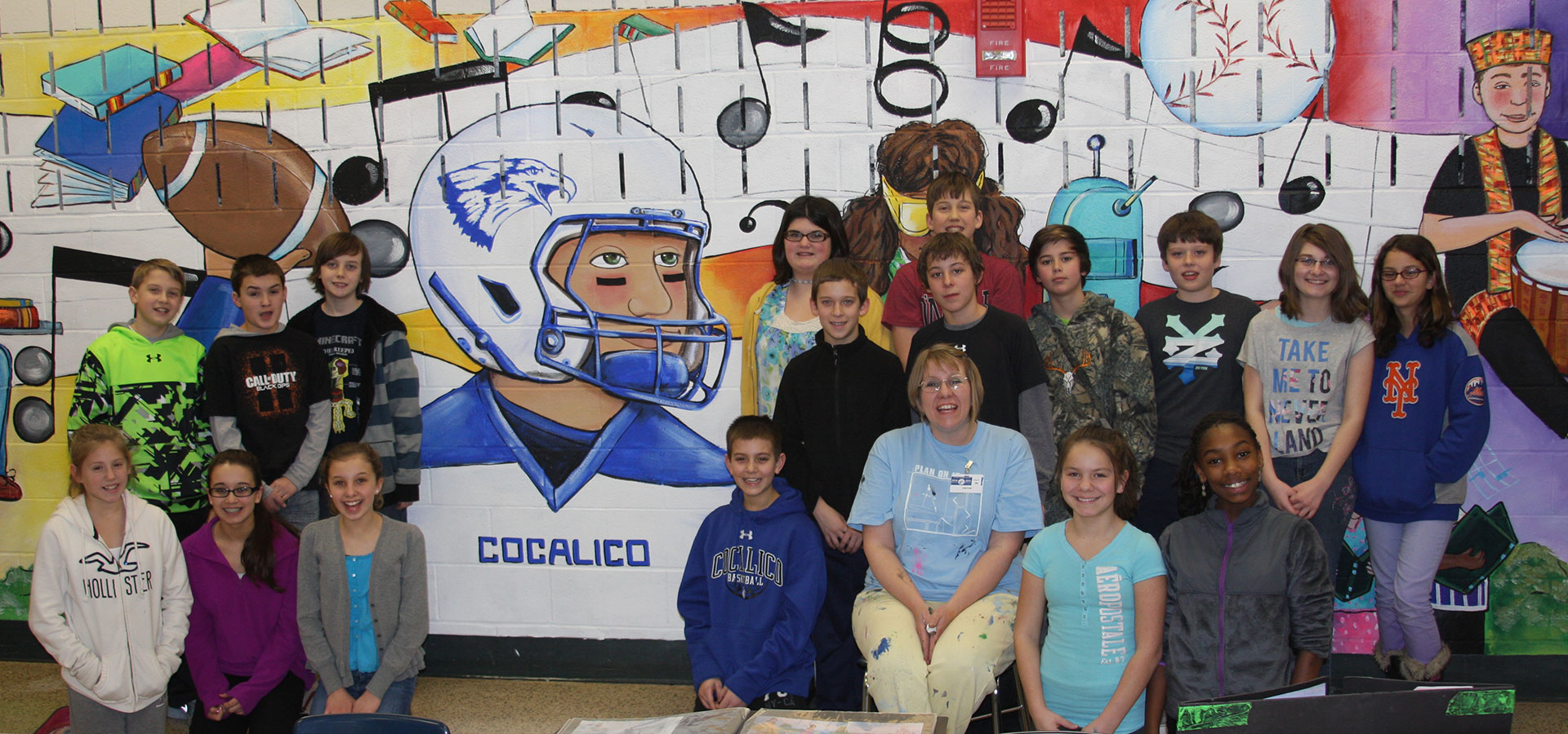 Students posing in front of mural